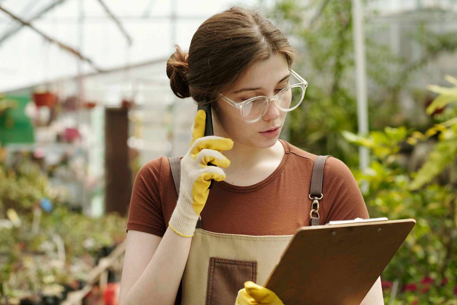 Mulher ao telefone em ambiente de jardinagem